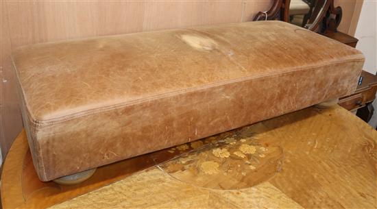 A modern tan leather long footstool
